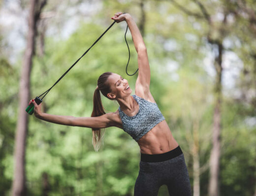 Woman pulling a rope or resistance band doing exercise amongst nature